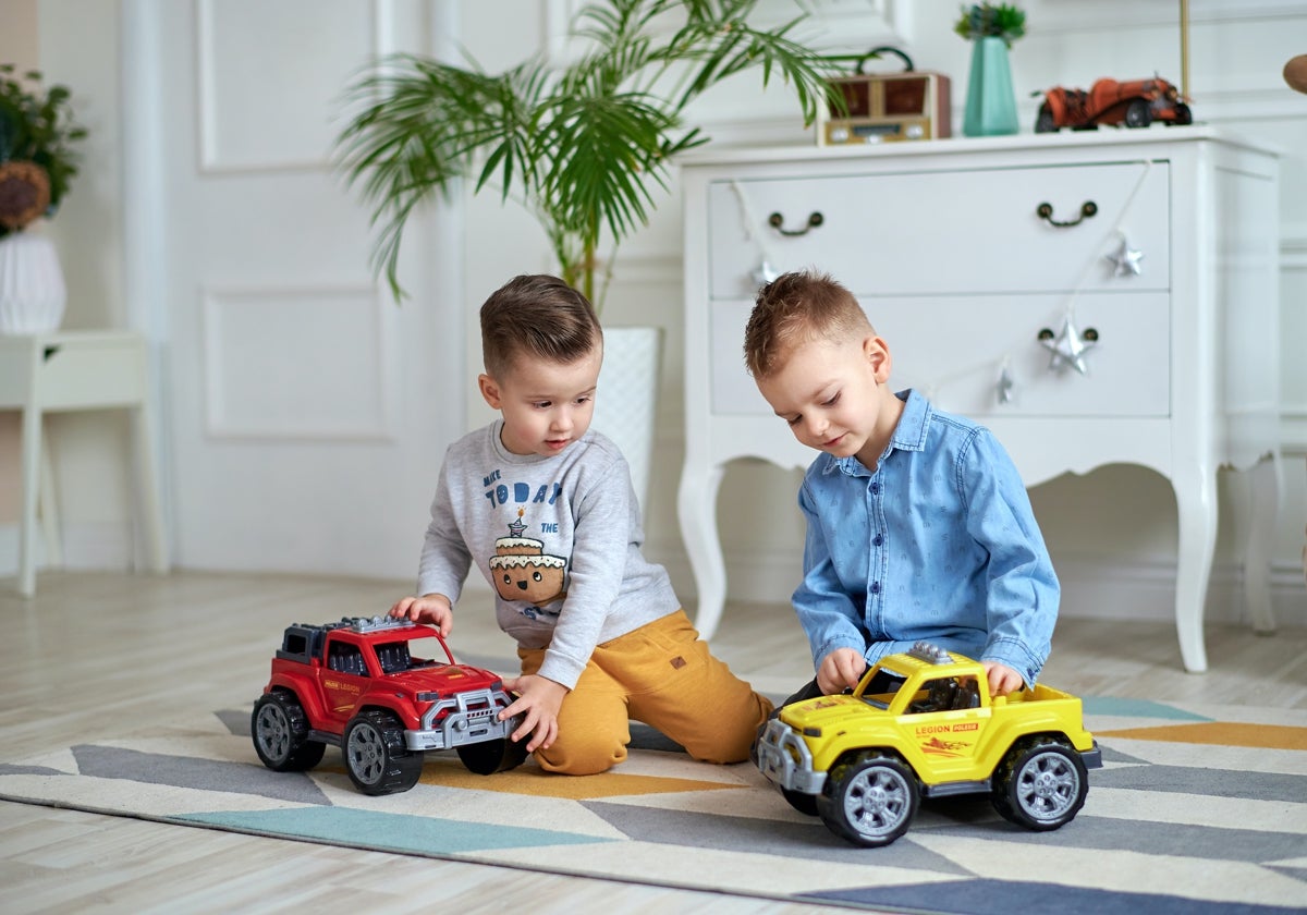 Dos niños jugando con coches